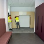 Aufbau von Büromöbeln in einem modernen Unternehmensflur mit professionellem Montageteam