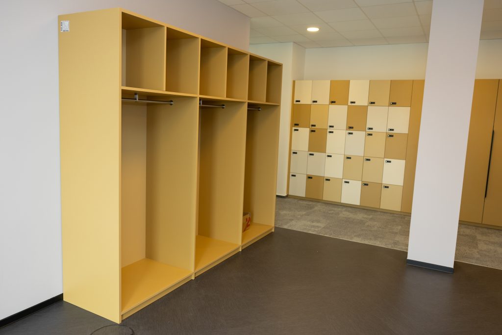 Moderne Schließfachanlage aus Holz mit Sitzbank in einem Umkleidebereich