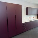 Moderne Einbauküche mit roten Hochglanzfronten und Kochinsel