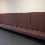 Lange Polsterbank im Empfangsbereich – fest montiert für wartende Besucherinnen und Besucher