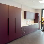 Monteur installiert Küchenschränke bei Nachrüstarbeiten im Innenraum